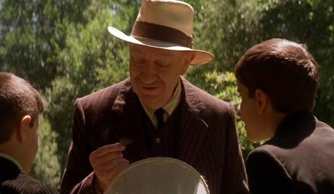 영화 ‘마리포사’에서 그레고리오 선생님(가운데)은 나비를 관찰하며 학생들에게 보이지 않는 나비의 혀에 대해 설명한다. 동숭아트센터 제공