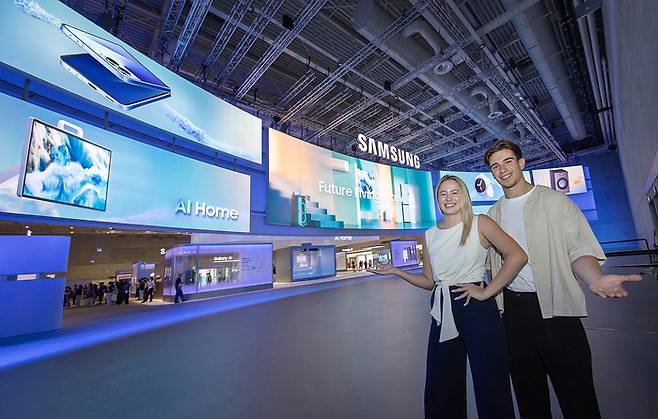 'IFA 2025'가 열리는 독일 베를린 '메세 베를린(Messe Berlin)'의 '시티큐브 베를린(City Cube Berlin)'에 위치한 삼성전자 전시관 입구에서 삼성전자 모델이 전시 주제인 'AI 홈, 미래 일상을 현실로 (AI Home - Future Living, Now)'를 소개하고 있다.