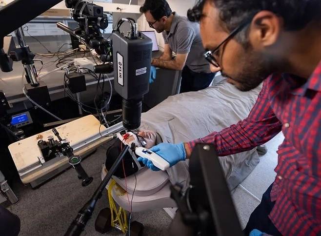 연구진이 체온을 높여주는 특수복을 입은 실험 참가자들의 이마에서 땀이 흘러나오는 모습을 관찰하고 있다. 애리조나주립대 제공