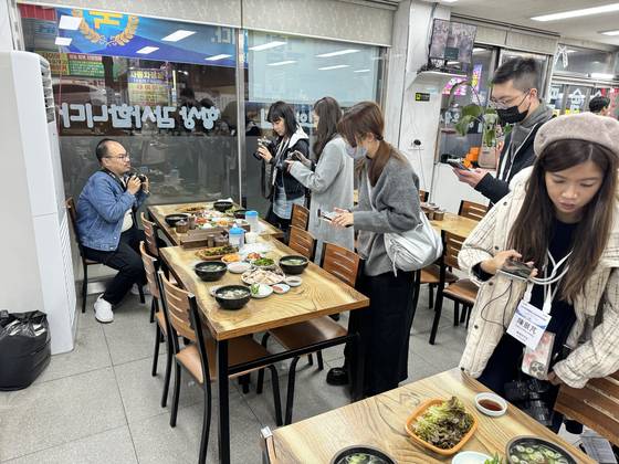 지난해 부산에 미쉘린 팸투어를 온 대만 인플루언서들이 돼지국밥 집에서 촬영을 하고 있다. [사진 부산시]