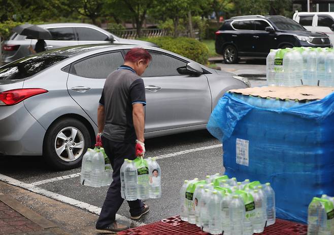 4일 강원 강릉 교1동 한 아파트에서 주민이 지원받은 생수병을 옮기고 있다. 연합뉴스