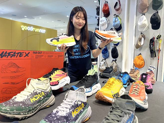 롯데백화점 부산본점 관계자가 호카 매장에서 러닝화를 홍보하고 있다. 롯데백화점 제공.