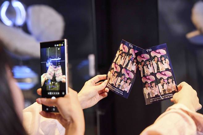 서울 성동구 ‘T 팩토리(T Factory) 성수’에서 방문객이 ‘AI 포춘 포토’를 촬영한 후 네 컷 사진을 보고 있다. [SK텔레콤 제공]