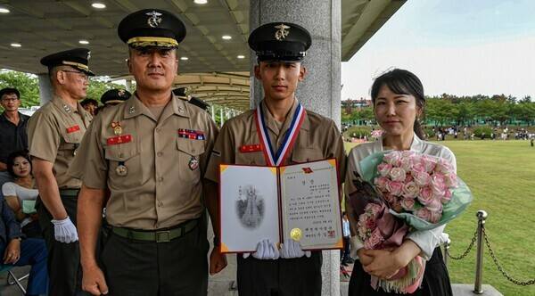 해병대 교육훈련단에서 열린 해병 1320기 수료식에서 우수한 성적으로 수료한 김지율 이병이 이종문 해병대교육훈련단장과 기념촬영을 하고 있다.