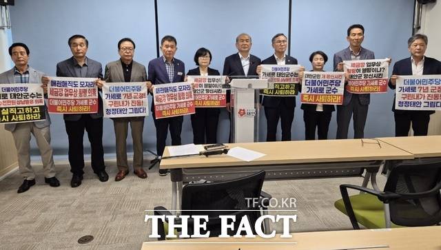 국민의힘 소속 태안군수 출마 예정자 및 군의회 의원 출마 예정자 10명이 5일 태안군청 브리핑룸에서 기자회견을 하고 있다. 이들은 가세로 태안군수에 대해 제기된 의혹과 관련해 '군수 물러나라'는 미니 현수막을 들고 있다. /이수홍 기자