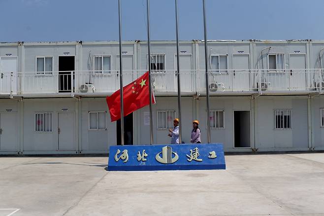 2024년 4월 26일, 엘살바도르 산티아고 텍사쿠앙고스에서 중국이 자금을 지원해 건설 중인 새로운 정수장 건설 현장을 둘러보는 동안 중국 노동자들이 중국 국기를 게양하고 있다. /연합뉴스