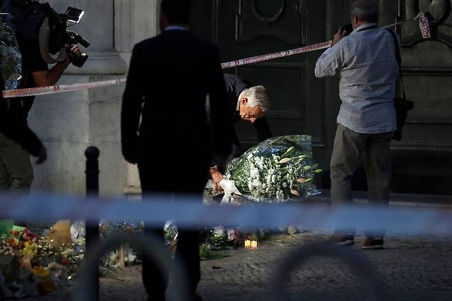 마르셀루 헤벨루 드 소우사 포르투갈 대통령이 4일 리스본 글로리아 푸니쿨라(케이블전차) 사고 현장에서 희생자들을 기리기 위해 꽃다발을 바치고 있다. 3일 리스본의 명물인 푸니쿨라 탈선하며 많은 사상자가 발생하자 포르투갈은 4일을 국가 애도일로 선포했다. 리스본/AFP연합뉴스