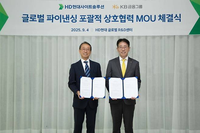 KB금융그룹이 해외 건설기계 관련 금융시장 진출을 위해 HD현대사이트솔루션과 손잡았다고 5일 밝혔다. 조영철 HD현대사이트솔루션 사장(왼쪽)과 이재근 KB금융지주 글로벌사업부문장이 기념촬영을 하고 있다. KB금융그룹
