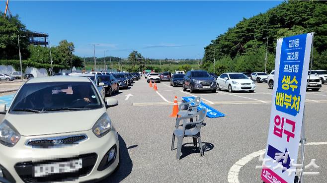 5일 오후 강릉시 스피드스케이팅경기장 주차장에 마련한 '드라이브 스루'를 통해 생수를 받으러 온 차량들이 늘어선 모습. 전영래 기자