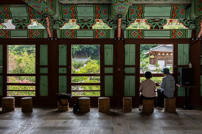 '능파교'와 '십바라밀 석주'가 내다보이는 누각에서 탐방객들이 담소를 나누고 있다. 창 너머 극락전 지역이 눈에 들어온다. / 양수열 영상미디어 기자