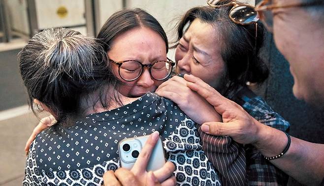 美서 비자 연장하려다 체포됐던 대학생 - 지난달 4일 미국 뉴욕 맨해튼의 이민세관단속국(ICE) 청사에 체포됐던 퍼듀대 재학생 고연수(왼쪽에서 둘째)씨가 구금 나흘 만에 석방된 후 성공회 사제인 어머니 김기리(왼쪽)씨를 끌어안고 눈물을 흘리고 있다. 고씨는 지난 7월 31일 비자 연장 신청을 한 뒤, 뉴욕 이민 법정에 불려 나갔다가 ICE 요원들에게 기습 체포됐다. /AFP 연합뉴스