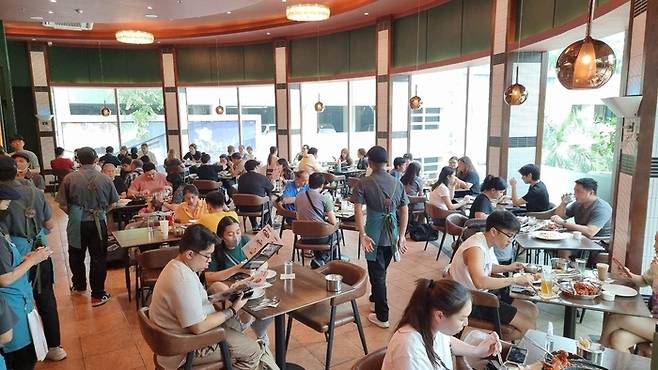 BBQ 로빈슨 마그놀리아점에 방문한 현지인과 관광객들이 BBQ 치킨을 즐기고 있다. [사진 출처 = BBQ]