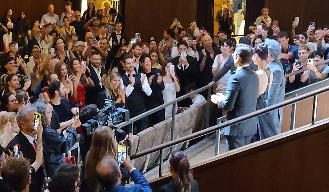 지난 29일(현지시간) 이탈리아 베네치아 리도섬의 살라 그란데 극장에서 열린 영화 '어쩔수가없다' 프리미어 상영회에서 박찬욱 감독, 배우 손예진, 이병헌이 상영이 끝난 뒤 관객들의 박수에 화답하고 있다. 연합뉴스