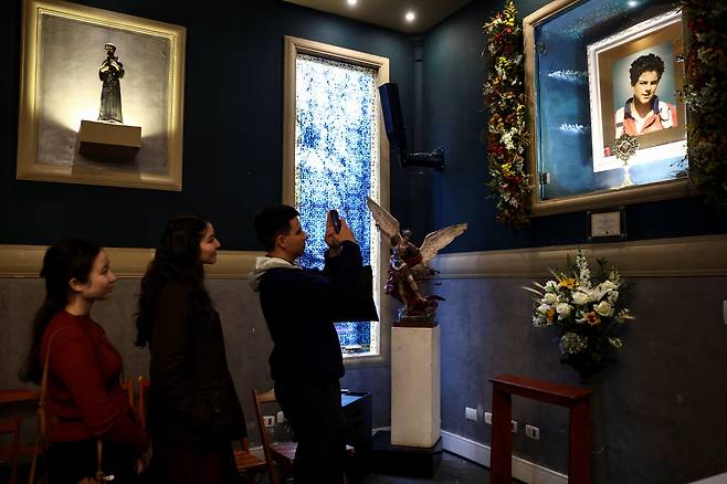 7일(현지시각) 브라질 상파울루 성 카를로 아쿠티스 성당에서 열린 시성 미사에 참석한 신자들이 아쿠티스의 유물 앞에 서 있다. /로이터·연합뉴스