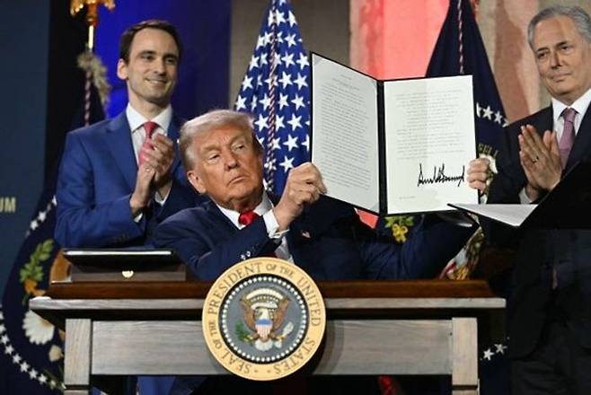 도널드 트럼프 대통령이 지난 7월23일 미 워싱턴DC 앤드루 W 멜론 오디토리엄에서 열린 ‘인공지능(AI) 경쟁에서 승리하기’ AI 서밋에서 AI 행정명령에 서명한 뒤 이를 들어 보이고 있다. ⓒ AFP/연합뉴스