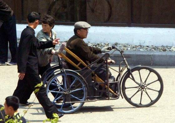 평양시 창광거리에서 한 장애인이 삼륜자전거를 타고 손으로 돌리며 지나가고 있다. 중앙포토