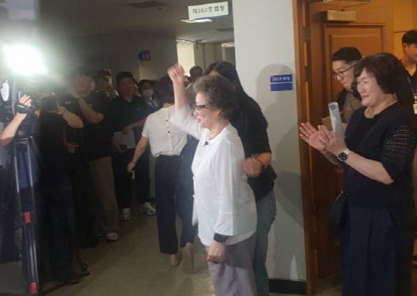 지난 23일 부산지법 형사5부 심리로 열린 재심 사건에서 최말자 씨가 공판기일 종료 후 재판정을 나서며 손을 들어보이고 있다. 신심범 기자