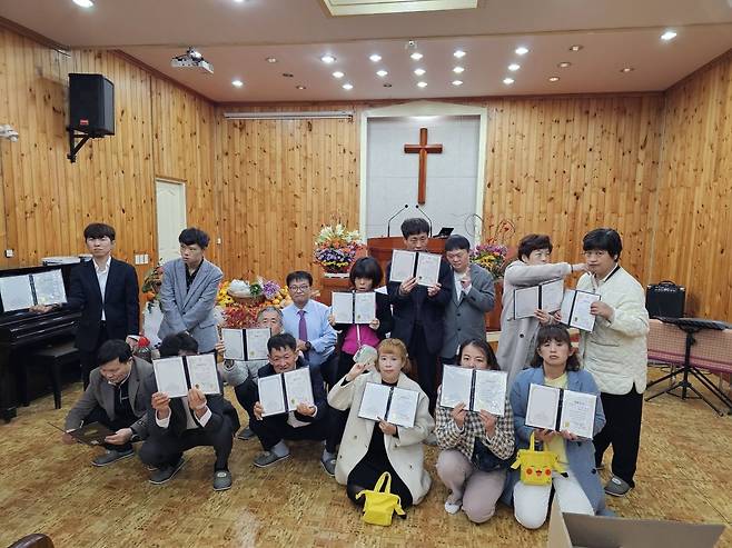 이태조 목사가 시무하는 교회의 성도들이 세례증을 들고 있다.  이 목사 제공