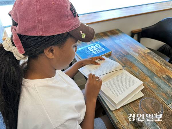 블레싱(토고·22)이 동두천의 집 근처 카페에서 전공책을 읽고 있다. 2025.8.30 /목은수기자 wood@kyeongin.com