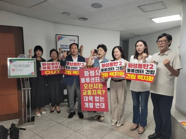 이권재 오산시장과 송진영 오산시의원(오른쪽 세 번째), 조미선 오산시의원(오른쪽 두 번째)이 참석자들과 동탄2 물류센터 건립 반대를 촉구하는 구호를 외치고 있다. [사진=경인방송]