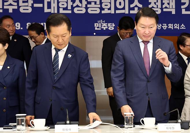 정청래 더불어민주당 대표와 최태원 대한상공회의소 회장이 8일 오전 서울 중구 대한상의에서 열린 정책 간담회에서 참석자들과 기념촬영을 마친 뒤 자리에 앉고 있다. /뉴스1