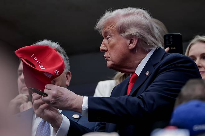7일(현지시간) 미국 뉴욕에서 열린 US오픈 테니스 남자 단식 결승전에 참석한 도널드 트럼프 미국 대통령이 모자에 서명하고 있다. EPA연합뉴스