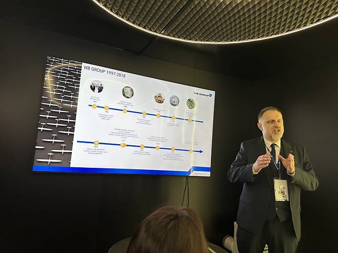 WB Group Communication Director Remigiusz Wilk speaks with a delegation of Korean reporters at the WB Group booth during MSPO 2025 in Kielce, Poland, on Sept. 2. [SEO JI-EUN]