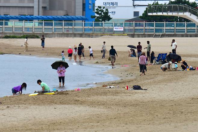 절기상 백로인 지난 7일 경북 포항시 북구 영일대해수욕장에서 시민과 관광객들이 백사장에서 더위를 식히고 있다.  [사진 = 뉴스1]