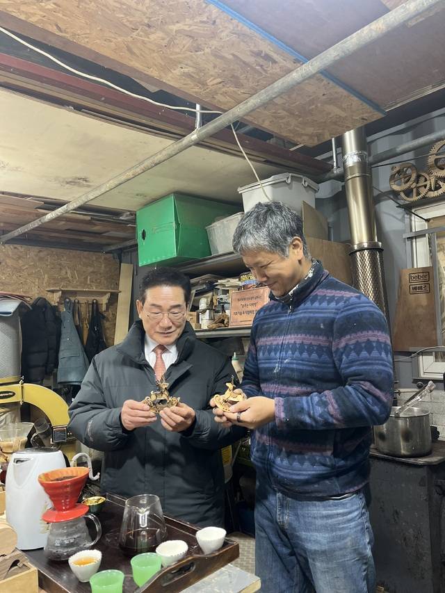 최기문 시장(왼쪽)이 나무 장난감 및 원목 도마를 제작하는 박재민 베베르 대표에게 제품 설명을 듣는 모습. 영천시 제공