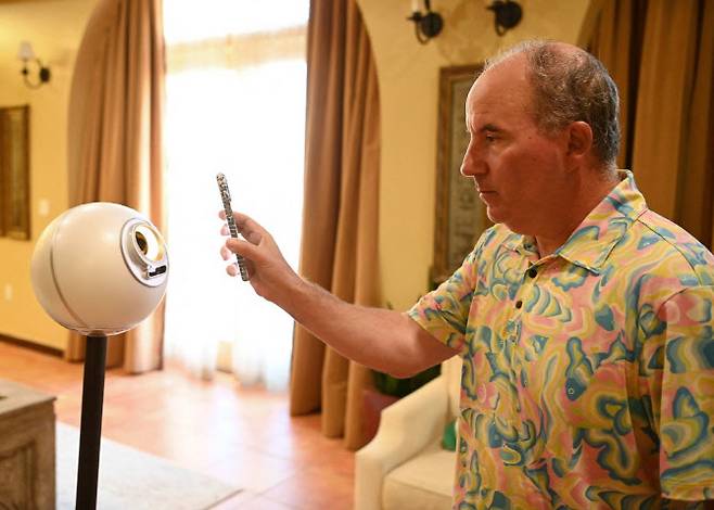 캘리포니아 헌팅턴 비치에 위치한 하얏트 헌팅턴 비치에서 에잇코 홀딩스(OCTO)의 댄 아이브스 이사회 의장이 월드코인 프로젝트의 홍체 인식 구형 장비인 오브(Orb)를 사용하고 있다. (사진=AFP)