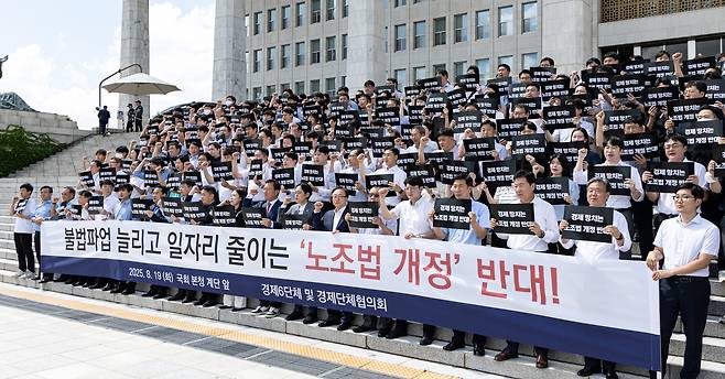 Members of the six major business associations and the Federation of Korean Industries chant slogans during a rally in front of the main building of the National Assembly in Yeouido, western Seoul, on Aug. 19, urging revisions to the amendment of the Labor Union Act. The front banner reads, “Oppose the amendment to the Labor Union Act that increases illegal strikes and reduces jobs.” [YONHAP]