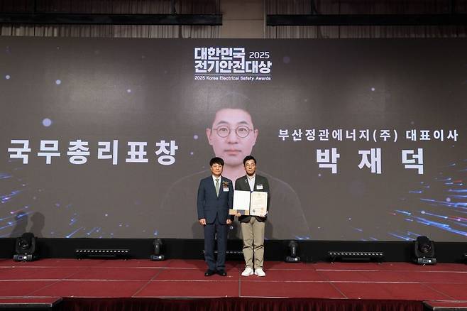 박재덕 부산정관에너지 대표이사(오른쪽)가 서울 광진구 세종대 컨벤션센터에서 열린 ‘2025 대한민국 전기안전대상’에서 전기안전관리 유공 국무총리 표창을 수상하고 있다. SK이노베이션 E&S 제공