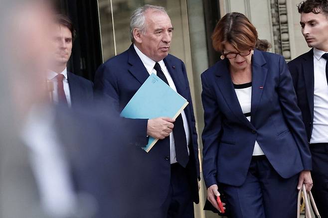 8일(현지시간) 프랑수아 바이루 프랑스 총리(왼쪽)가 하원 신임 투표에서 불신임이 결정된 직후 아니 제네바르 농업·식량주권부 장관과 이야기를 나누며 의사당을 떠나고 있다. [AFP = 연합뉴스]