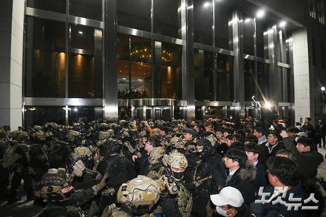 윤석열 전 대통령이 비상계엄을 선포했던 지난해 12월 4일 새벽 서울 여의도 국회에서 경내로 진입하려는 계엄군과 저지하려는 시민 및 국회 관계자들이 대치하고 있다. 박종민 기자
