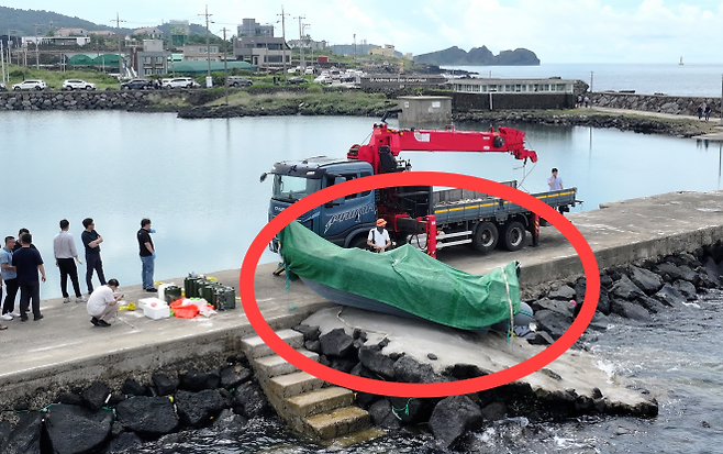 해경과 경찰 등 관계자들이 8일 오전 제주시 한경면 용수리 해안가에서 이날 오전 발견된 미확인 보트를 조사해 인양하려 하고 있다. 해당 보트는 중국인 밀입국자들이 탔던 것으로 확인됐다. 연합뉴스
