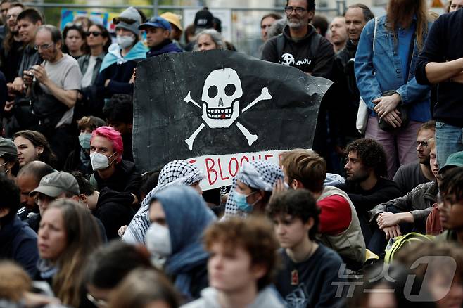 10일(현지시간) 프랑스 파리 북역(Gare du Nord) 앞에서 열린 '모든 것을 멈춰라'(Bloquons Tout) 시위에 참여한 시민 한 명이 거리 한복판에 앉아 길을 막으며 해적기를 들어올리고 있다. 2025.09.10. ⓒ 로이터=뉴스1 ⓒ News1 윤다정 기자