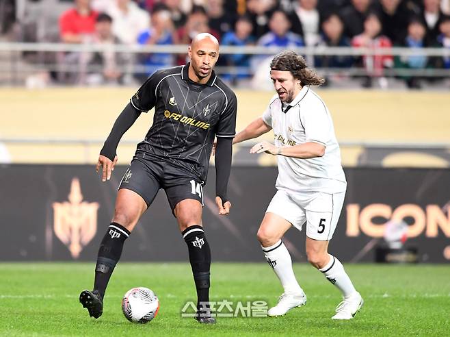 티에리 앙리(왼쪽)가 20일 서울월드컵경기장에서 열린 FC 스피어와 쉴드 유나이티드의 ‘2024 넥슨 아이콘 매치’에서 카를레스 푸욜의 공을 빼앗고 있다. 박진업 기자 upandup@sportsseoul.com