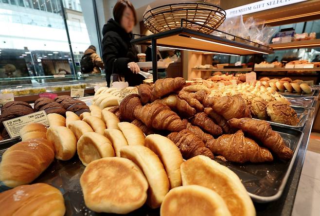 서울의 한 프랜차이즈 베어커리 매장에서 소비자가 빵을 고르고 있다.      [뉴시스]