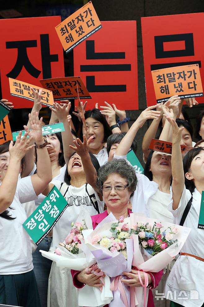 [부산=뉴시스] 하경민 기자 = 61년 전 성폭행에 저항하는 과정에서 가해자의 혀를 깨물어 1.5㎝가량 절단하는 상해를 입혔다는 이유로 가해자보다 더 중한 형을 선고받았던 최말자(79)씨가 재심에서 무죄를 선고받았다.  10일 부산 연제구 부산지방법원 앞에서 최씨가 여성단체 회원들과 함께 무죄 선고에 기뻐하고 있다. 2025.09.10. yulnetphoto@newsis.com