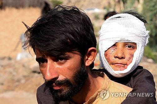 지진으로 다친 아들 업은 아버지 [AFP 연합뉴스. 재판매 및 DB 금지]
