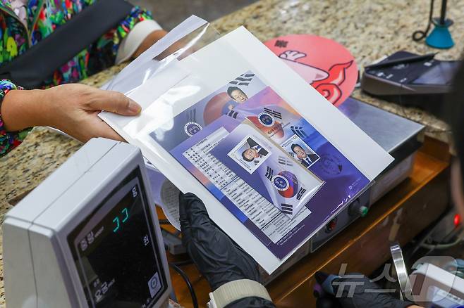 이재명 대통령 취임 100일 기념우표 판매가 시작된 11일 서울 중구 서울중앙우체국에서 한 시민이 우표를 구매하고 있다. (공동취재) 2025.9.11/뉴스1 ⓒ News1 민경석 기자