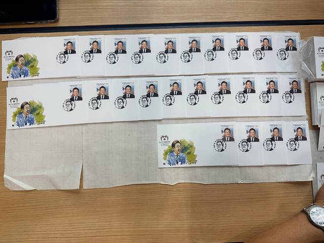 11일 서울중앙우체국에서 이재명 대통령 취임 기념우표를 구매한 시민이 현장에서 봉투에 도장을 찍고 있다. /이호준 기자