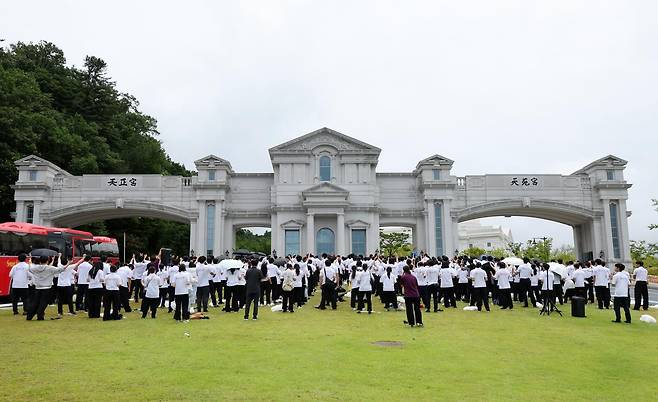 김건희 여사 의혹을 수사하는 민중기 특별검사팀이 통일교 압수수색에 들어간 18일 오후 경기 가평군 천원궁 앞에서 통일교 외국인 신자들이 기도를 하고 있다. 2025.07.18 뉴시스