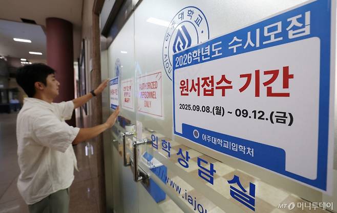 2026학년도 수시모집 원서 접수가 시작된 8일 경기 수원시 영통구 아주대학교 입학처 앞에 관계자가 2026학년도 수시모집을 알리는 게시물을 부착하고 있다/사진=뉴스1 /사진=(수원=뉴스1) 김영운 기자