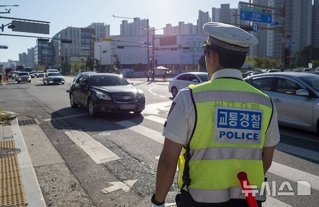 [전주=뉴시스] 강경호 기자 = 11일 오전 전북 전주시 완산구 효자동의 한 사거리에서 진행된 경찰의 '5대 반칙운전' 집중 단속 현장에서 경찰이 주행 중인 차량들의 법규 위반 여부 사항을 유심히 지켜보고 있다. 2025.09.11. lukekang@newsis.com
