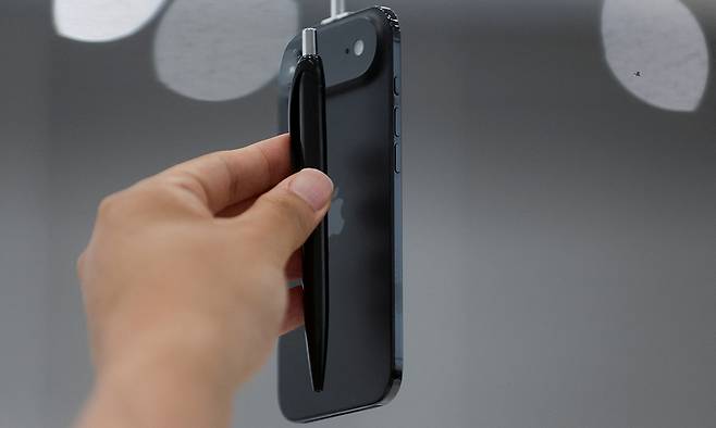 9일(현지시간) 미국 캘리포니아주 쿠퍼티노에서 열린 애플의 신제품 공개 행사에서 한 참석자가 애플의 초슬림폰 ‘아이폰 에어’와 펜의 두께를 비교하고 있다. 쿠퍼티노=로이터연합뉴스