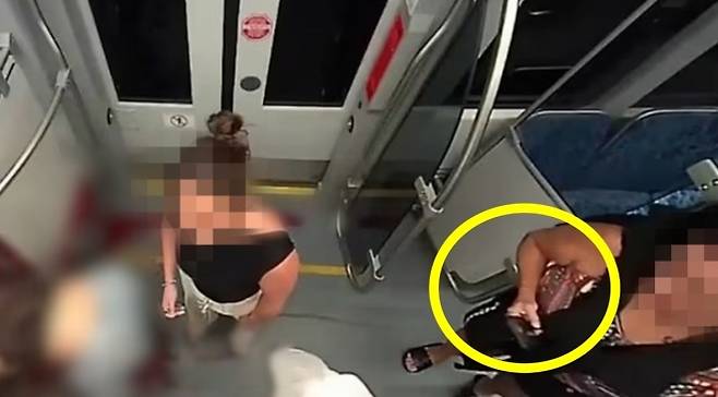 지난달 22일 우크라이나 출신 난민 여성인 이리나 자루츠카(23)가 노스캐롤라이나주(州) 샬럿의 지하철에서 흉기에 찔려 숨진 현장에서 휴대전화로 이를 촬영하는 여성(오른쪽)