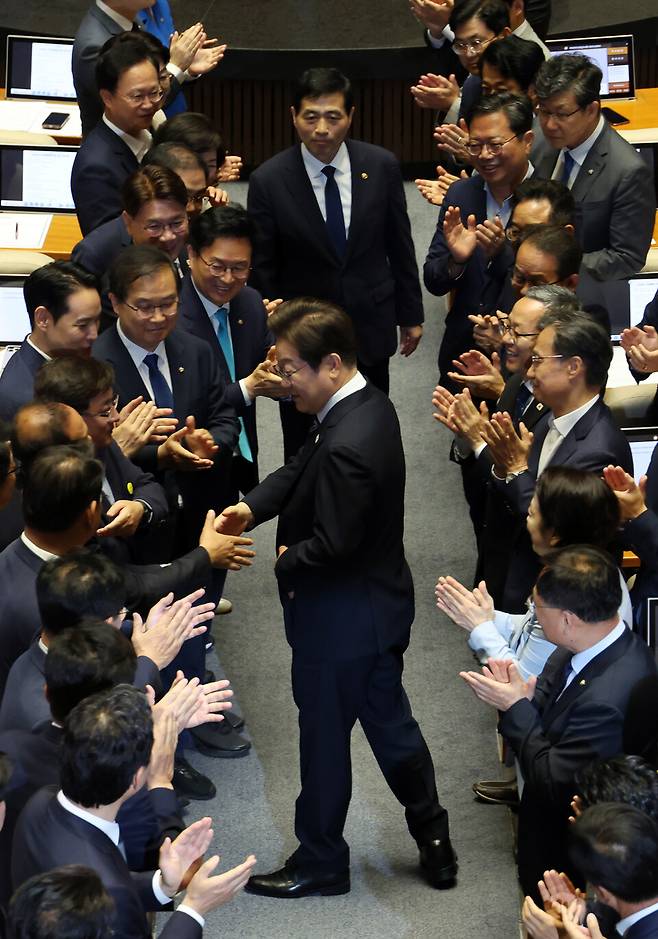 이재명 대통령이 6월26일 서울 여의도 국회에서 열린 본회의에서 추가경정예산 시정연설을 하기 위해 입장하며 의원들과 인사를 하고 있다. ⓒ국회사진기자단