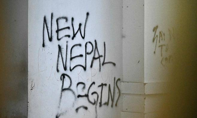 지난 11일 네팔 수도 카트만두에서 시위대가 불을 지른 뒤, 네팔 정부 청사 건물 벽에 적어 놓은 메시지. 벽에는 ‘새로운 네팔이 시작된다’라는 내용의 낙서가 적혀 있다. AFP 연합뉴스