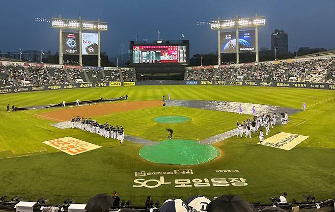 13일 잠실 LG-NC전이 우천 순연된 뒤 양 팀 선수들이 그라운드로 나와 팬들에게 인사하고 있다. 잠실=이형석 기자&nbsp;